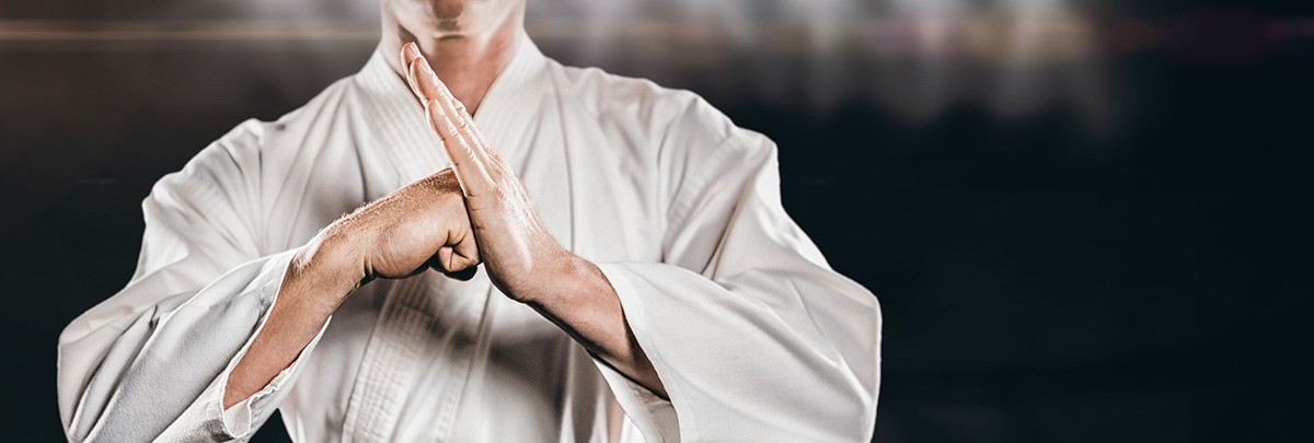 Karateka im weißen Anzug in Grußhaltung